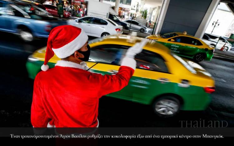 <p>Ένας τροχονόμοςντυμένος Άγιος Βασίλης ρυθμίζει την κυκολοφορία έξω από ένα εμπορικό κέντρο στην Μπανγκόκ.</p>